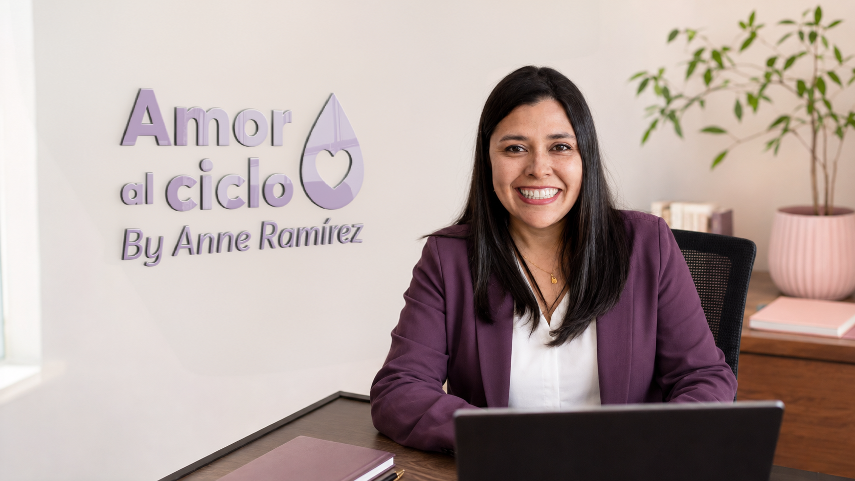 Anne Julieth Ramírez en su escritorio con la laptop, con el logo de Amor al Ciclo detrás
